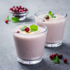 Winter detox drink cranberry banana smoothie on concrete or stone background. Selective focus, copy space, close up. 