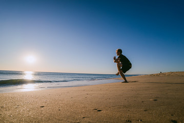 Man doing Yoga at sunset on a beach in Portugal