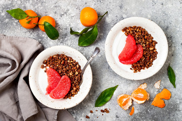 Healthy winter breakfast. Greek yogurt bowl with chocolate gingerbread granola and grapefruit. Top view, flat lay, overhead