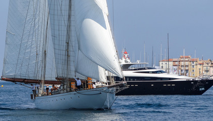 Obraz premium Sailing yacht and motorboat on anchorage of St. Tropez Bay