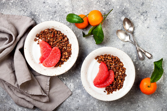 Healthy winter breakfast. Greek yogurt bowl with chocolate gingerbread granola and grapefruit. Top view, flat lay, overhead