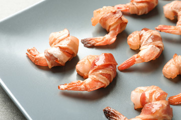 Shrimps wrapped in bacon on plate, closeup