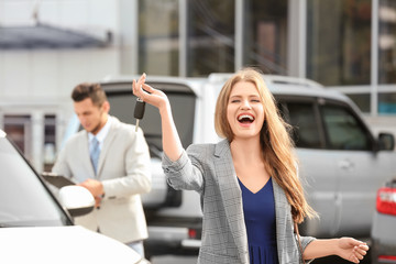 Happy customer with key near new car outdoors