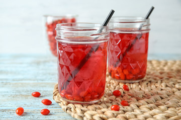 Mason jars with healthy goji juice on wooden table