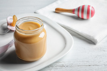 Jar with healthy baby food on table
