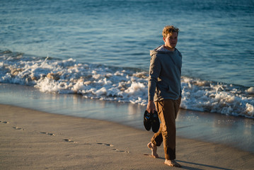 Man watching the sunrise and walking around on the beach in Portugal