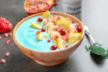 Bowl with blue spirulina smoothie on table. Healthy vegan food concept