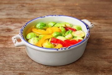 Vegan soup with Brussels sprouts in bowl on wooden table