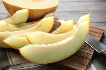 Board with yummy melon on table, closeup