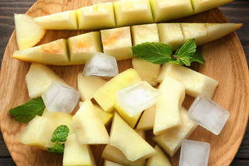 Plate with yummy melon slices on table