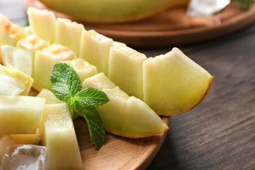 Board with sliced yummy melon on table