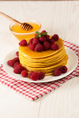 Fresh made delicious pancakes with berries, blackberries, raspberries, banana, honey and maple syrup. Healthy morning breakfast concept.