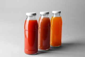 Bottles with juices on light background
