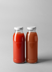 Bottles with juices on light background