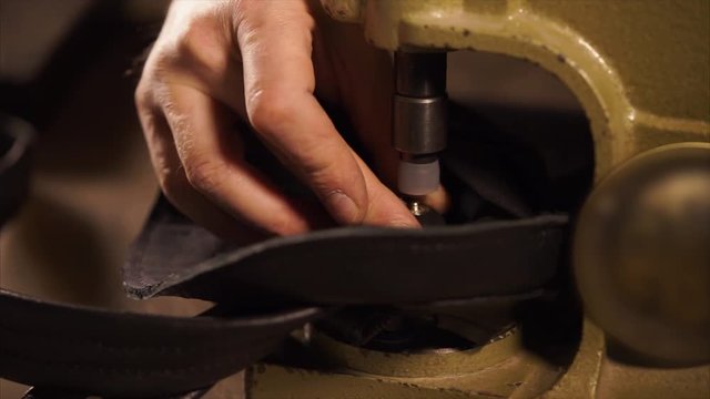 Craftsman is using press for installing metal fittings. He is fixing detail with clincher in a tool and putting down handle, pressing
