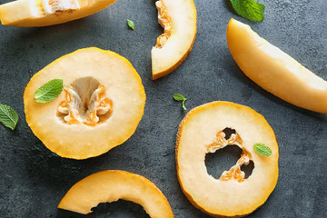 Yummy cut melon on grey background, top view