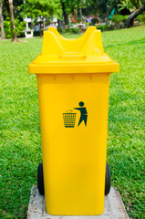 yellow refuse bin in park