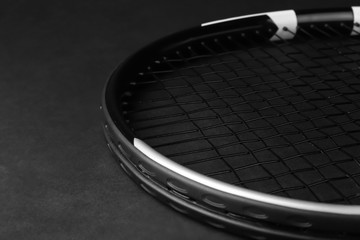 Tennis racket on dark background, closeup