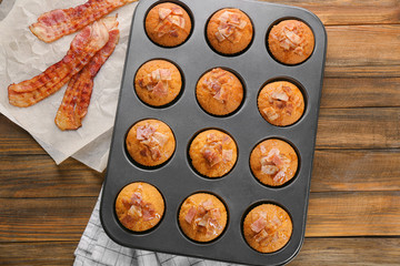 Tasty bacon muffins in mold on table