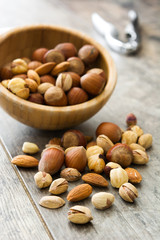 Assorted mixed nuts in bowl on wooden table