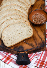 Whole wheat bread with flax seeds, sliced on a cutting Board. Selective focus