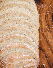 Slices of whole grain flax bread on chopping Board closeup. Selective focus