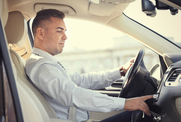 Man tuning radio in car