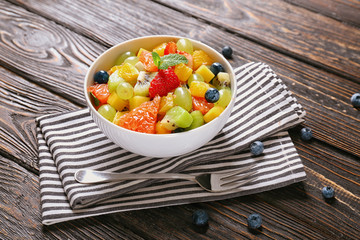 Bowl with delicious fruit salad on table