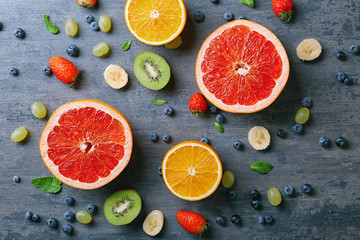 Delicious ripe fruits and berries on grey background