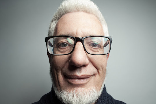 Fabulous at any age. Self-portrait, Eyewear concept. Portrait of a handsome mature man looking at camera in his hands. Close up. Studio shot