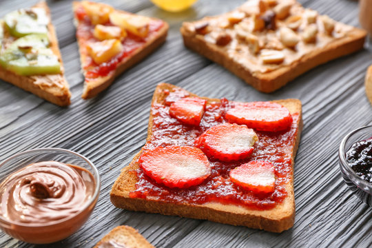 Slice of bread with jam and strawberry on table
