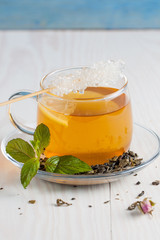 A glass cup of green natural tea with ginger, lemon, mint and honey on wooden rustic background. Healthy drink.