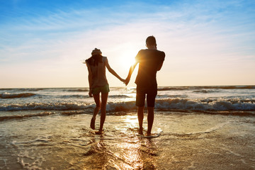 Couple enjoying a romantic evening on the beach at sunset