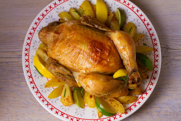Whole roasted chicken or turkey with potatoes, lemons and limes. View from above, top, horizontal