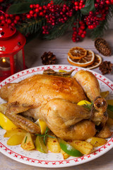 Whole roasted chicken or turkey with potatoes, lemons and limes on Christmas and New Year background, vertical