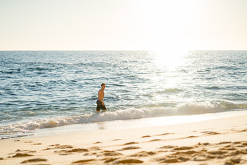 Fototapeta na wymiar Man running on the beach at sunset