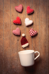 cup with heart shapes and Santa Claus hat