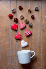 cup on lying on side with Christmas baubles and heart shapes
