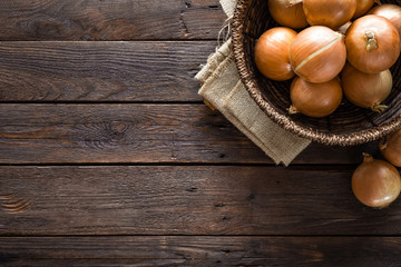 Fototapeta na wymiar Fresh onion in basket on wooden table, top view