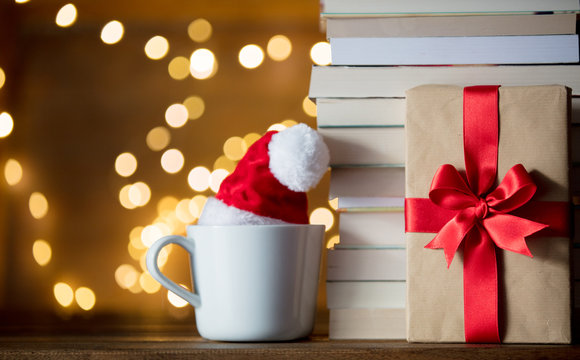 White Cup With Christmas Hat And Books