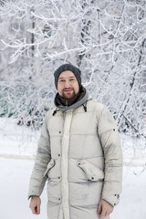 Fototapeta na wymiar Attractive man on the winter lanscape background