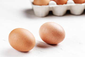 Raw, brown, chicken eggs on wooden white boards. top view