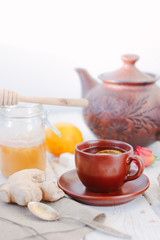 Ginger tea with lemon, lime and honey on white.