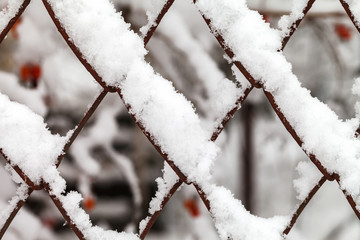 The grid of metal slabs is covered with snow.