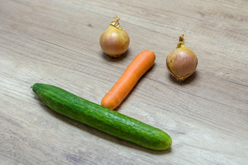 Fresh vegetable laying on a table in a face or smiley form