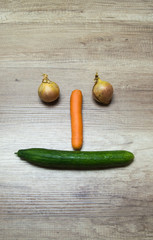 Fresh vegetable laying on a table in a face or smiley form