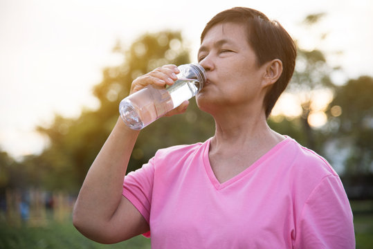 Asian senior Female drinking water.
