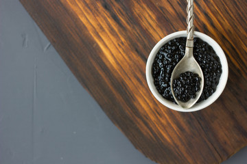 Top view of black caviar in a metal spoon.