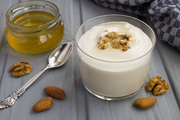 Milk yogurt with honey and nuts on the grey  wooden background