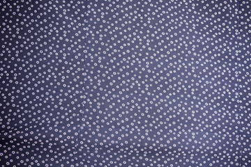 Flower background made of many flowers on the piece of fabric.
